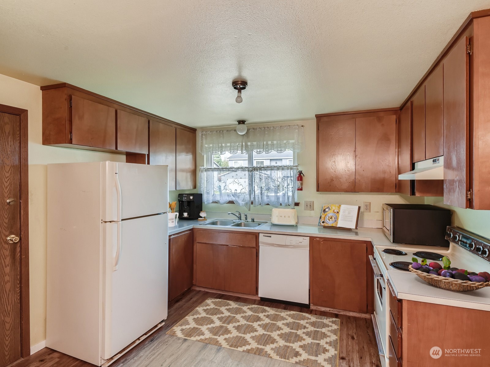 416 213th Street Southwest Bothell, WA 98021 - Photo 5 of 12 a kitchen with a sink a refrigerator and wooden cabinets