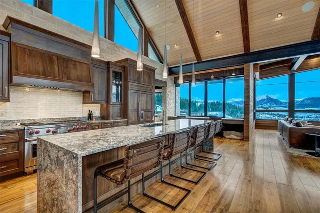 a kitchen with kitchen island a stove a counter space a sink and cabinets