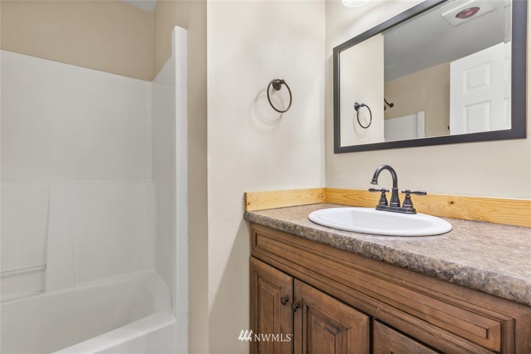17923 Charlotte Place Southwest Rochester, WA 98579 - Photo 13 of 24 a bathroom with a granite countertop sink and a mirror