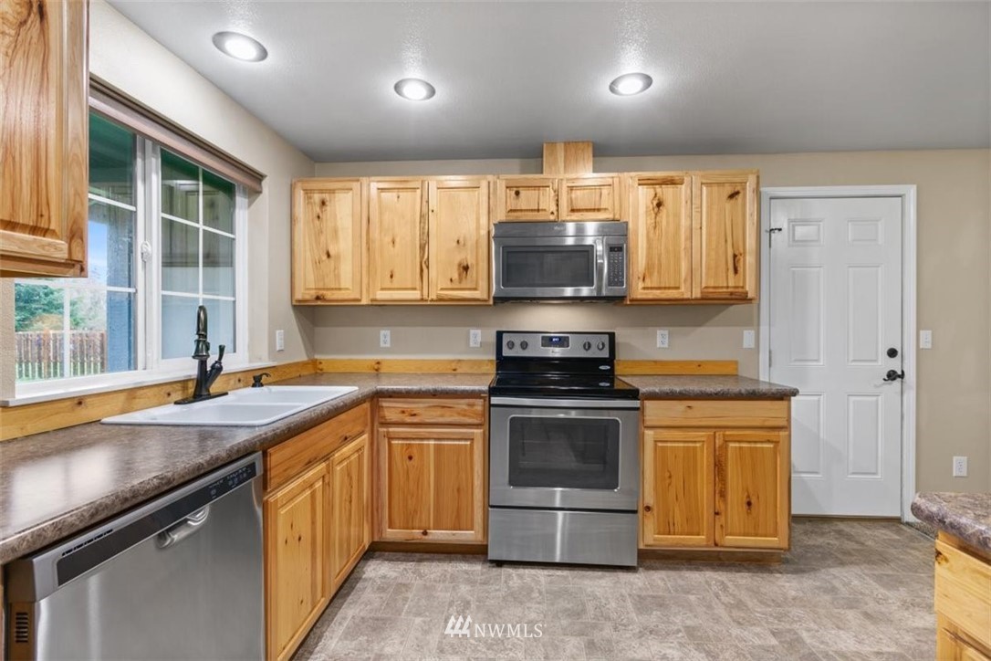 17923 Charlotte Place Southwest Rochester, WA 98579 - Photo 10 of 24 a kitchen with stainless steel appliances a stove a sink and a microwave
