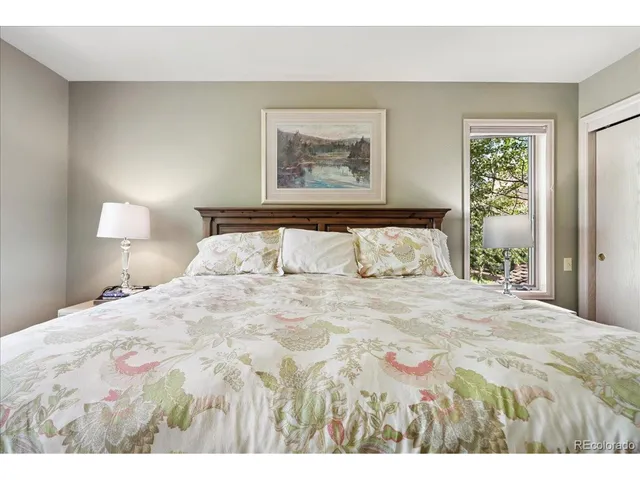 a bedroom with a bed and a ceiling fan with wooden floor