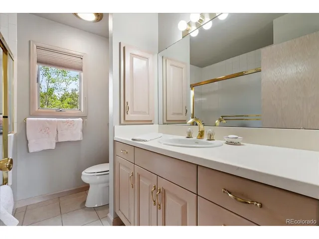 a en suite bathroom with a granite countertop sink and a mirror