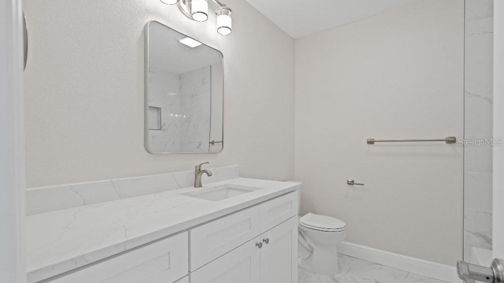 1024 Spindle Palm Way Apollo Beach, FL 33572 - Photo 15 of 50 a bathroom with a toilet a sink a vanity and mirror