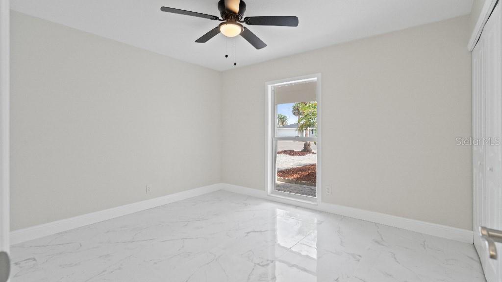 1024 Spindle Palm Way Apollo Beach, FL 33572 - Photo 17 of 50 an empty room with windows and ceiling fan