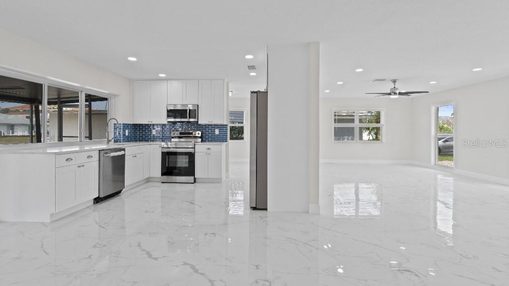 1024 Spindle Palm Way Apollo Beach, FL 33572 - Photo 21 of 50 a kitchen with stainless steel appliances granite countertop a stove top oven a sink and a refrigerator