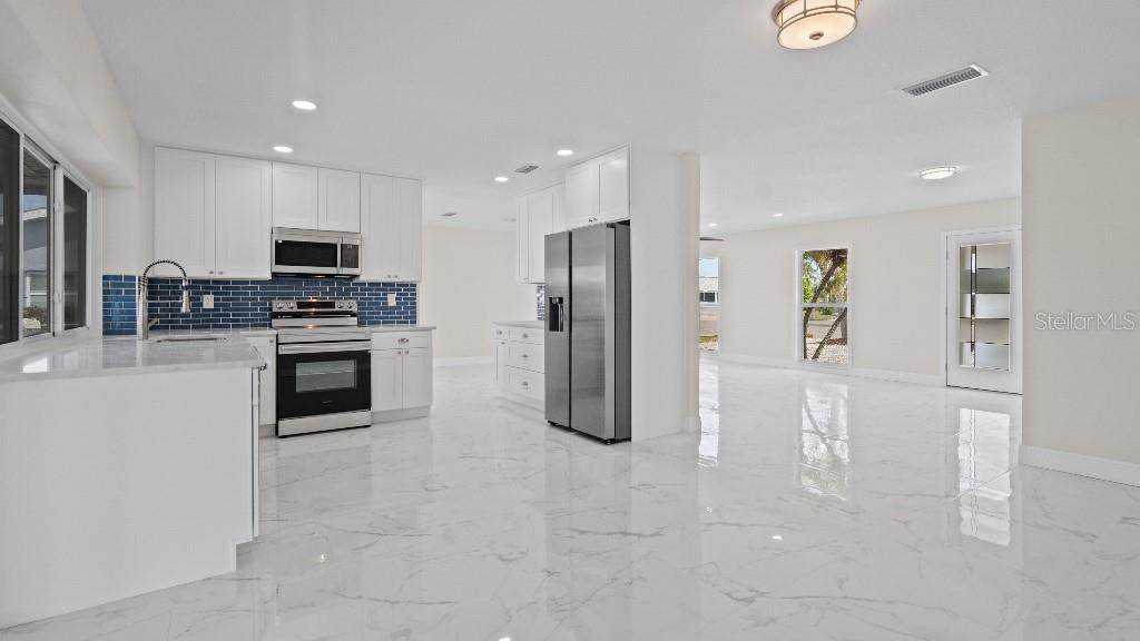 1024 Spindle Palm Way Apollo Beach, FL 33572 - Photo 44 of 50 a kitchen with stainless steel appliances granite countertop a refrigerator and a stove top oven