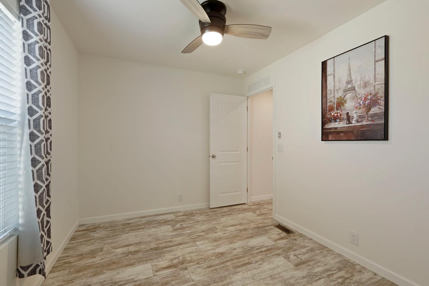 19250 North Lower Sacramento Road, Unit 22 Woodbridge, CA 95258 - Photo 14 of 30 wooden floor in an empty room with a window