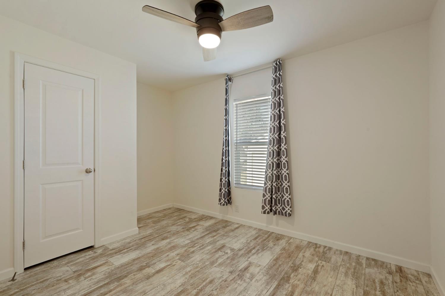 19250 North Lower Sacramento Road, Unit 22 Woodbridge, CA 95258 - Photo 15 of 30 an empty room with wooden floor cabinet and windows
