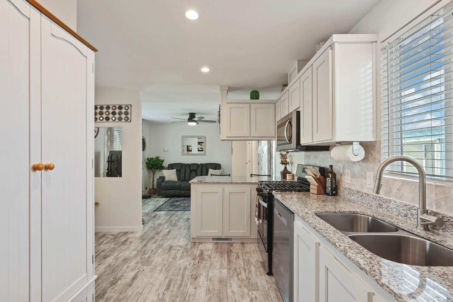 19250 North Lower Sacramento Road, Unit 22 Woodbridge, CA 95258 - Photo 17 of 30 a kitchen with a sink cabinets a counter top space and stainless steel appliances