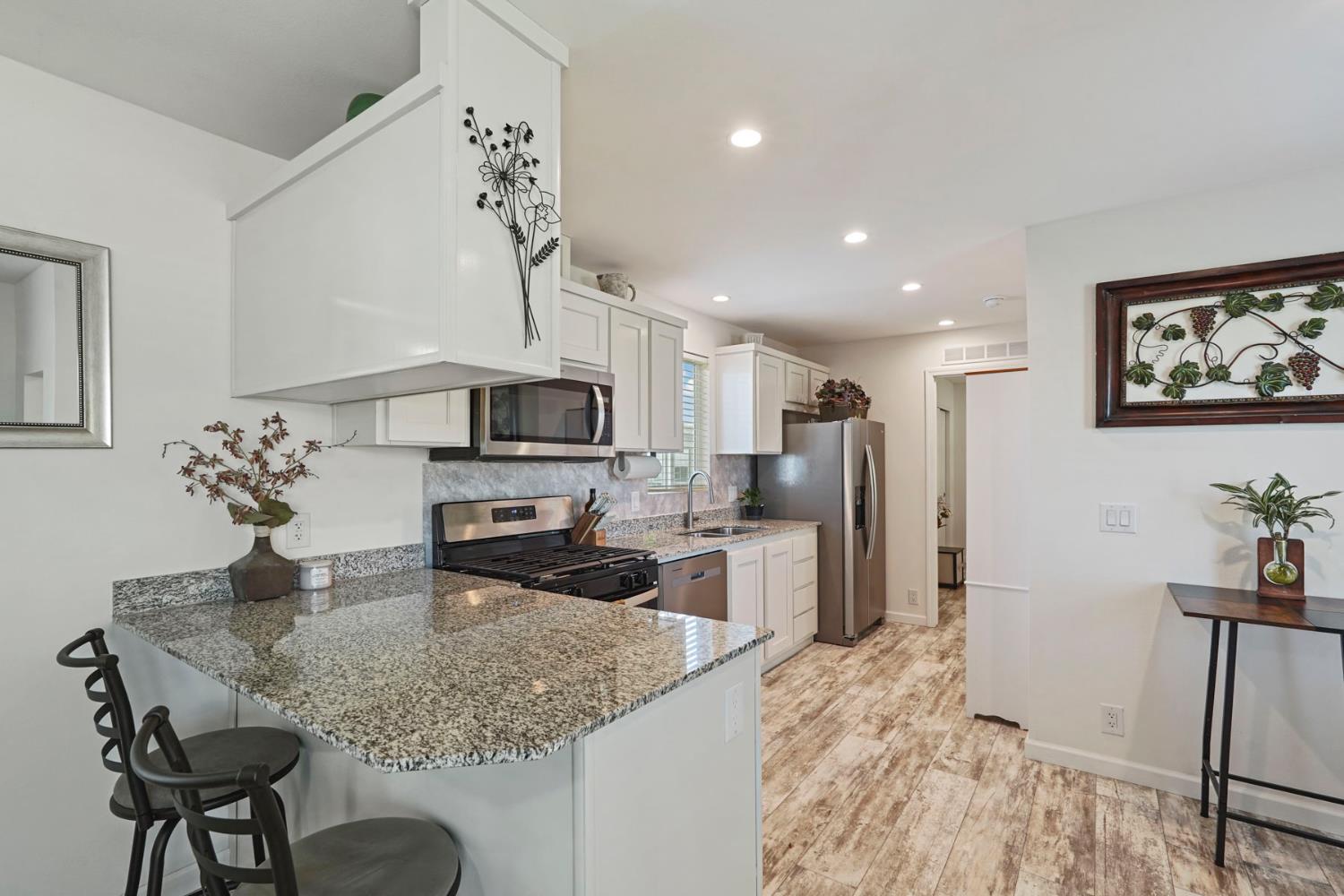 19250 North Lower Sacramento Road, Unit 22 Woodbridge, CA 95258 - Photo 18 of 30 a kitchen with stainless steel appliances granite countertop a sink refrigerator and cabinets