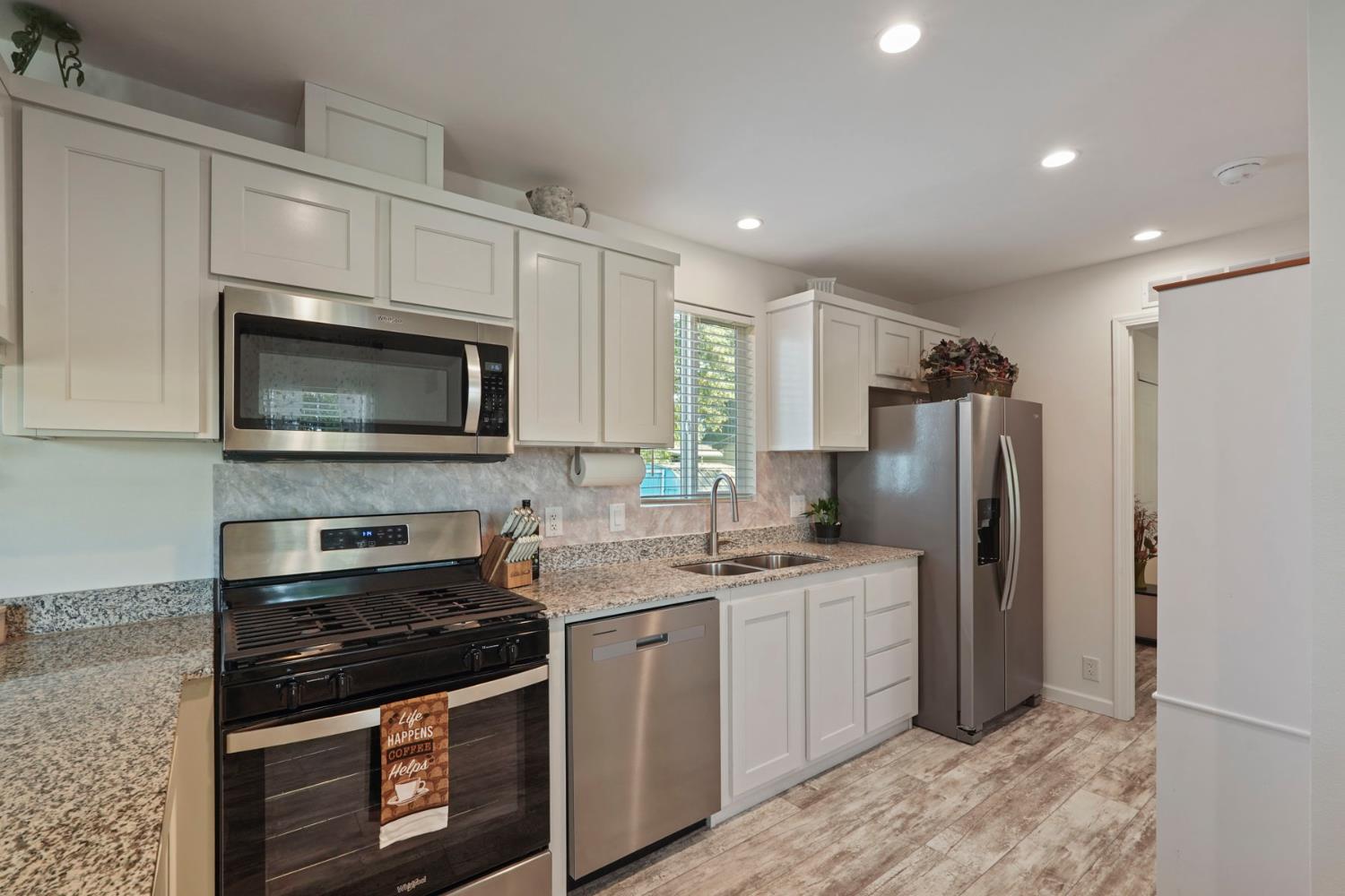 19250 North Lower Sacramento Road, Unit 22 Woodbridge, CA 95258 - Photo 7 of 30 a kitchen with stainless steel appliances granite countertop a stove a refrigerator and a microwave