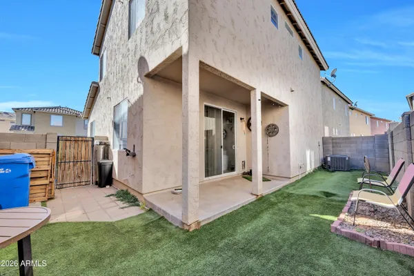 a view of backyard with barbeque grill potted plants and wooden fence