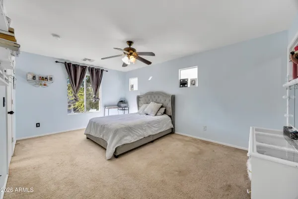 a spacious bedroom with a bed and a chandelier
