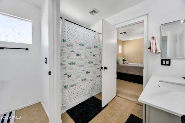 a bathroom with a double vanity sink a toilet and shower