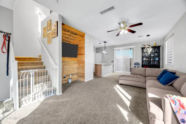 a living room with furniture and a ceiling fan