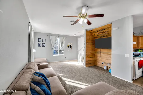 a living room with furniture and a ceiling fan