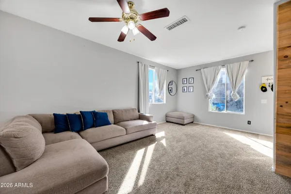a living room with furniture ceiling fan and a window