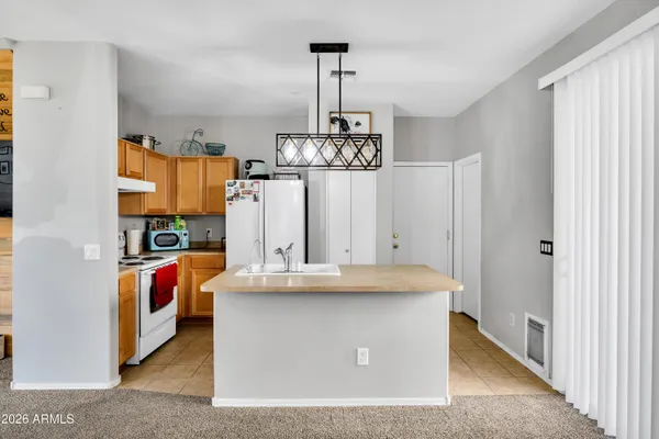a view of kitchen island with stainless steel appliances granite countertop furniture and a window