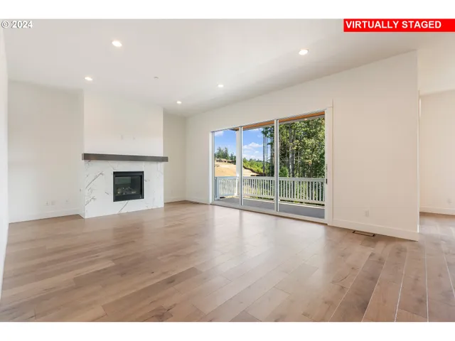 a view of empty room with wooden floor and fireplace