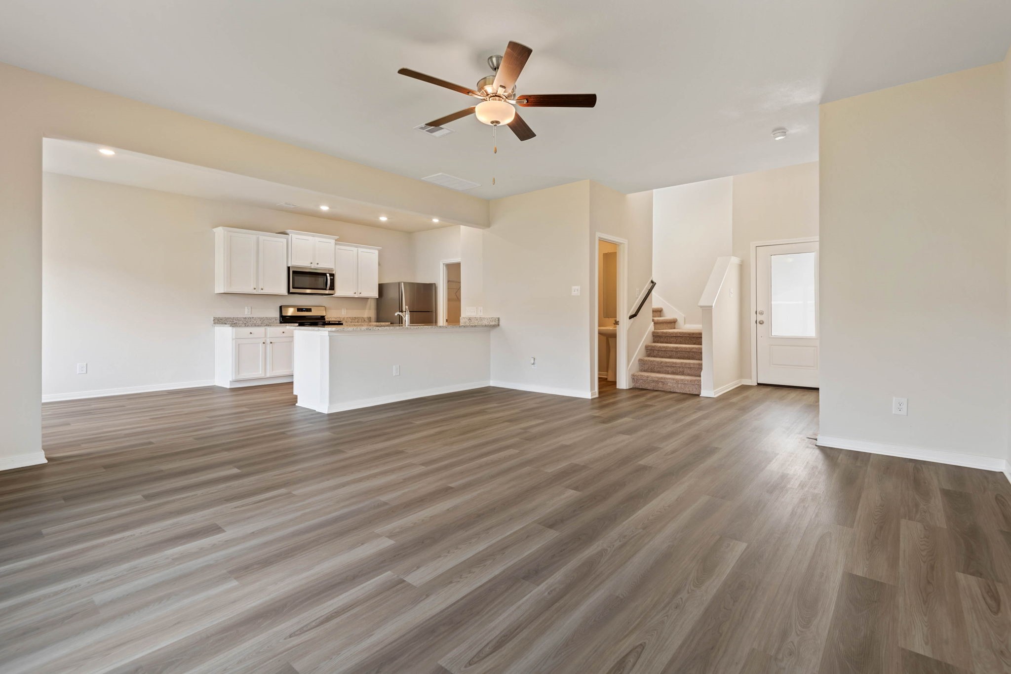 10339 Red Cardinal Drive Cleveland, TX 77328 - Photo 4 of 25 a view of a kitchen with wooden floor and a ceiling fan