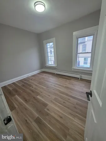 a view of empty room with window and wooden floor
