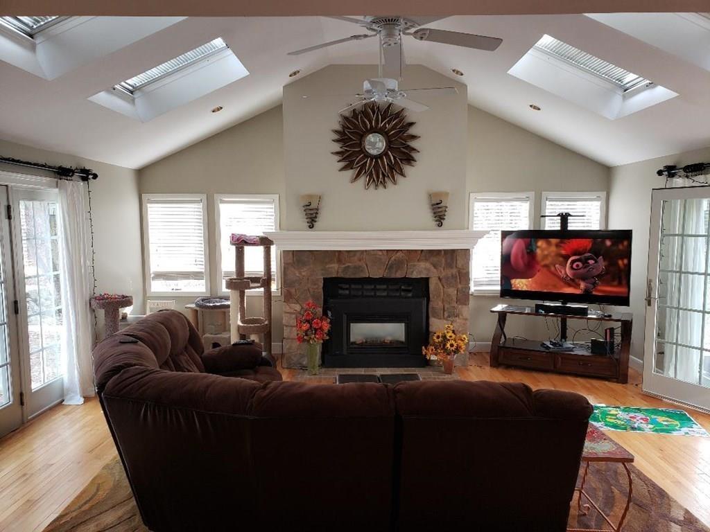 12 Hemlock Road Boxford, MA 01921 - Photo 14 of 42 a living room with furniture a flat screen tv and a fireplace