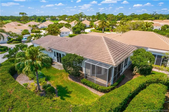a aerial view of a house with a yard and a large tree