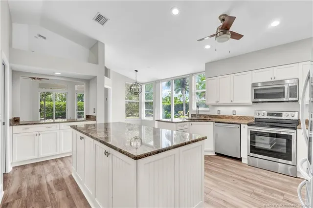 a kitchen with stainless steel appliances granite countertop a sink and microwave