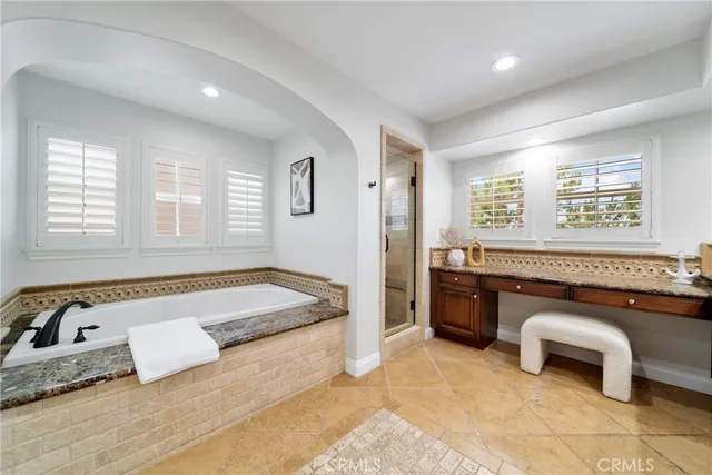 a spacious bathroom with a tub sink and mirror