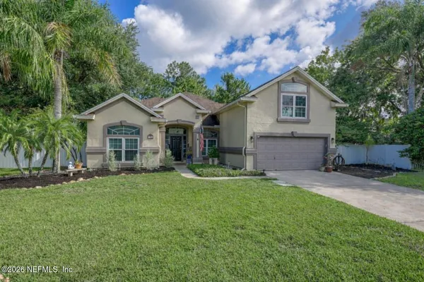 a front view of a house with a yard and garage