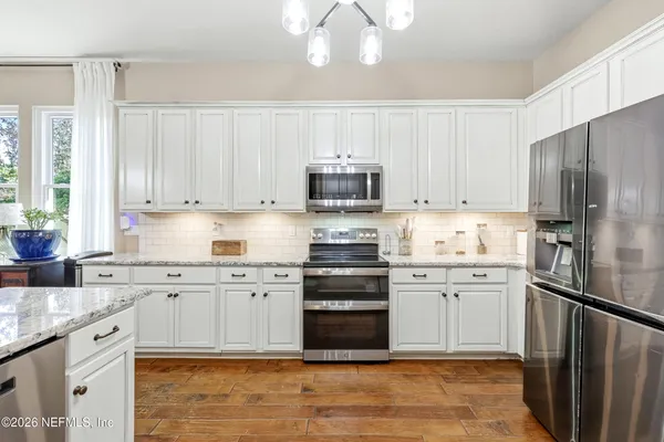 a kitchen with granite countertop a sink and white cabinets