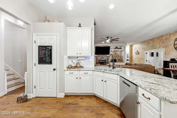 a kitchen with kitchen island granite countertop a sink cabinets and wooden floor
