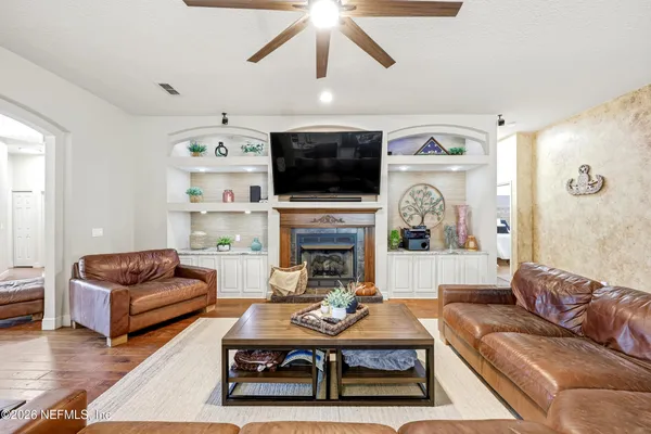 a living room with furniture a flat screen tv and a fireplace
