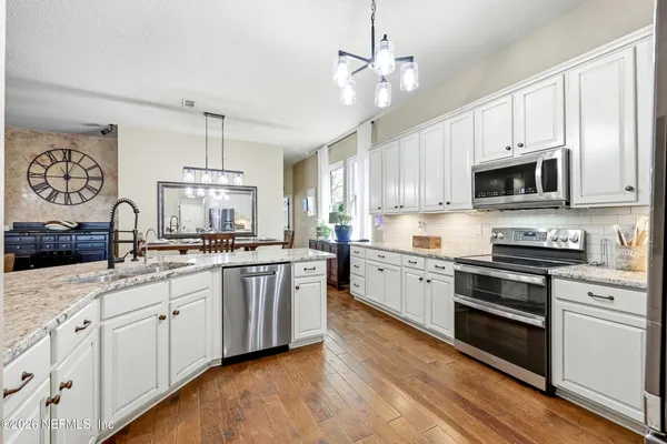 a kitchen with granite countertop a refrigerator stove and microwave