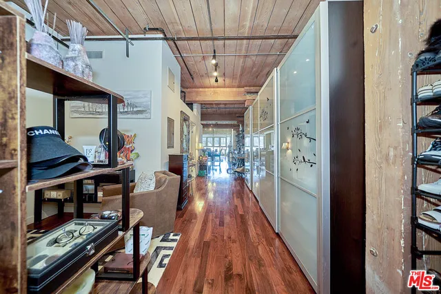 a view of a hallway with furniture and wooden floor