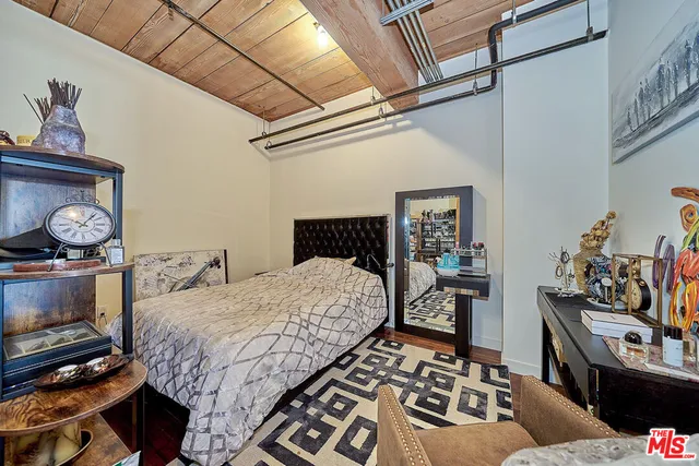 a bedroom with bed and wooden floor