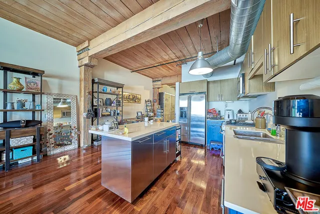 a kitchen with stainless steel appliances granite countertop a lot of counter space and wooden floors