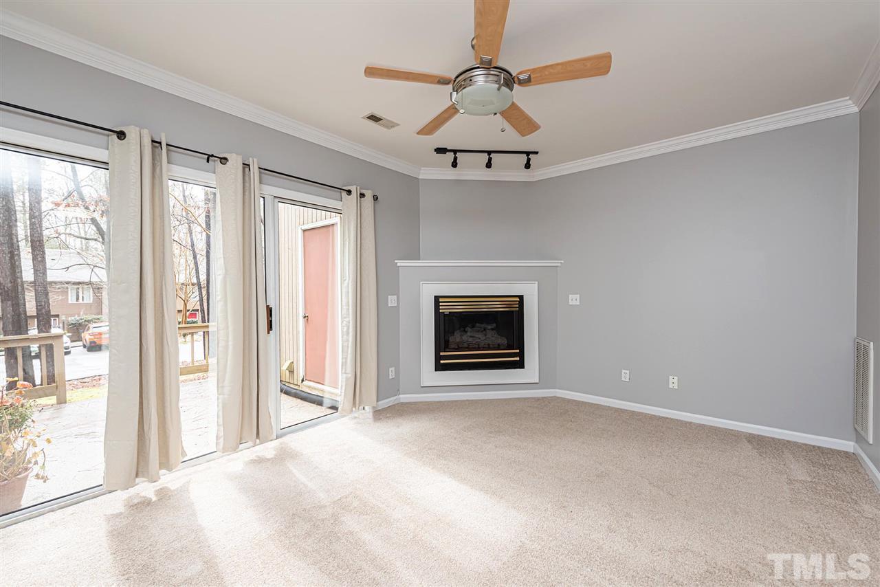 6305 Daystar Lane Raleigh, NC 27613 - Photo 3 of 19 a view of an empty room with a fireplace and a window