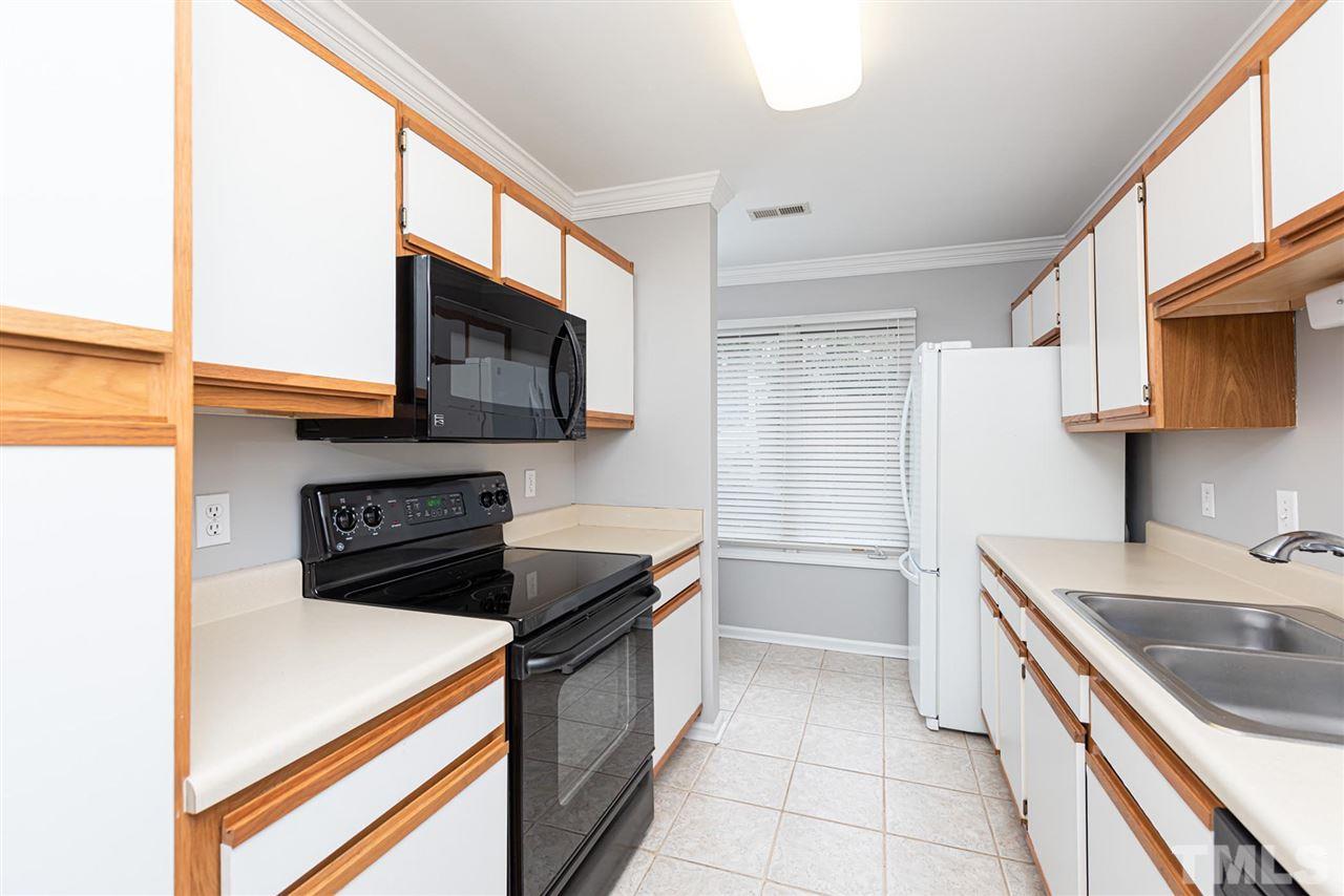 6305 Daystar Lane Raleigh, NC 27613 - Photo 7 of 19 a kitchen with a sink a microwave and cabinets