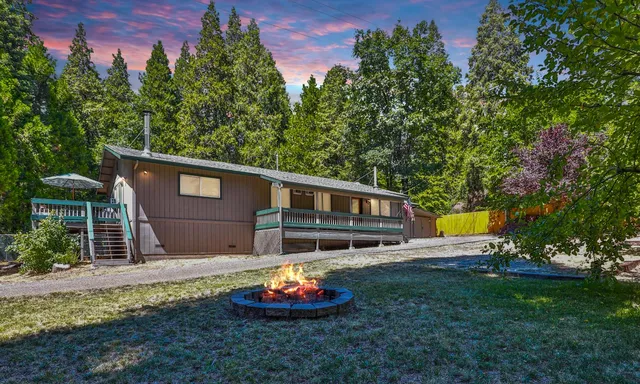 a front view of a house with a garden and trees