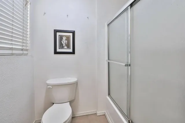 a white toilet sitting next to a shower