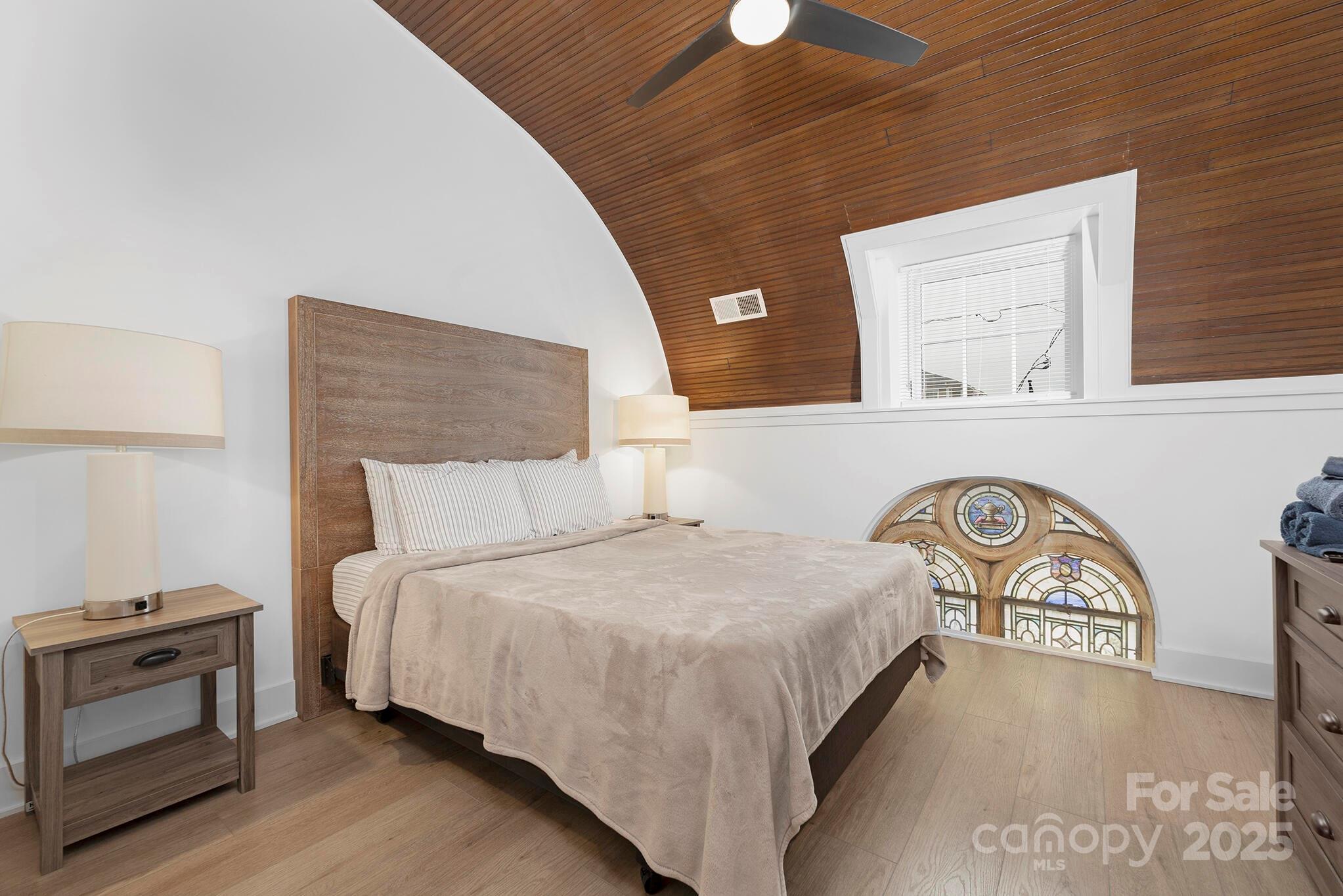 201 Grandin Road, Unit 13 Charlotte, NC 28208 - Photo 4 of 25 a bedroom with a bed and a night stand on the wall