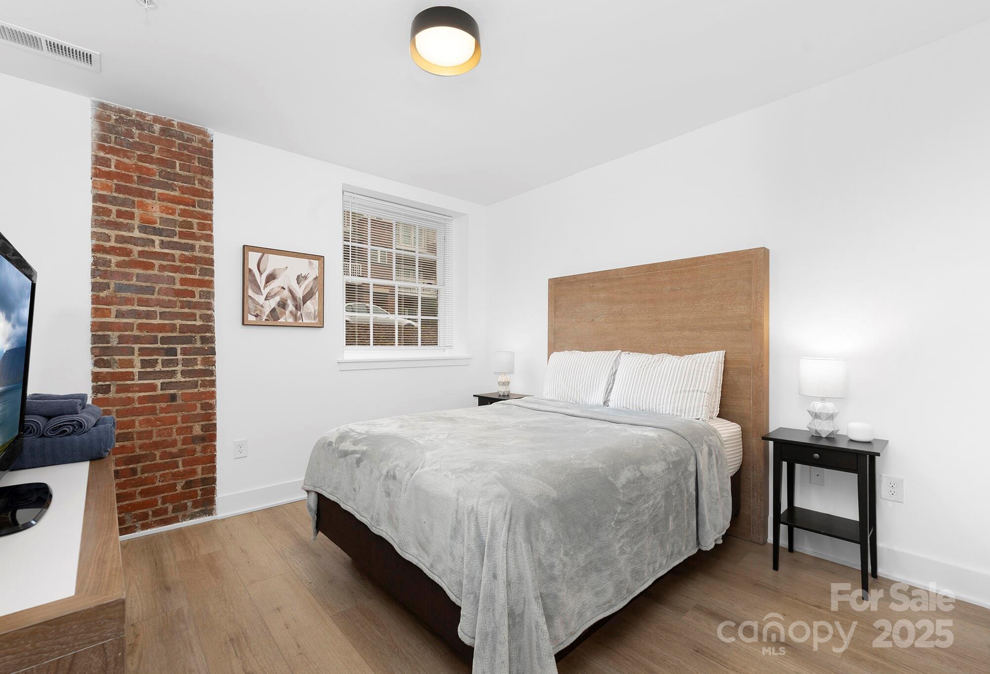 201 Grandin Road, Unit 13 Charlotte, NC 28208 - Photo 7 of 25 a bedroom with a bed and a flat screen tv