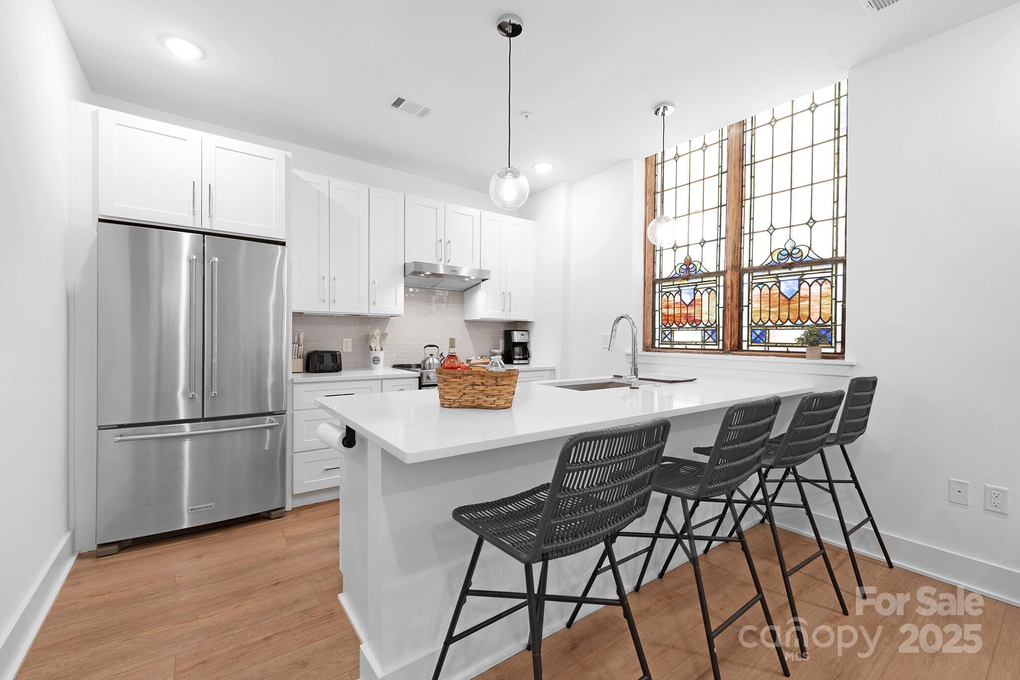 201 Grandin Road, Unit 13 Charlotte, NC 28208 - Photo 9 of 25 a kitchen with stainless steel appliances a refrigerator a stove a sink and a refrigerator with wooden floor
