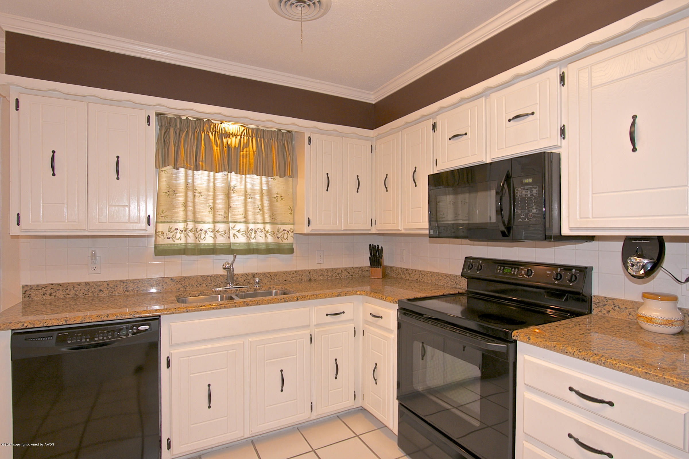 5701 South Fannin Street Amarillo, TX 79110 - Photo 5 of 15 a kitchen with granite countertop a sink dishwasher stove and white cabinets