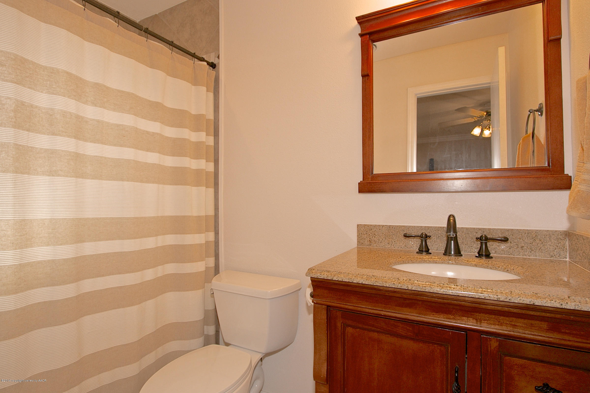5701 South Fannin Street Amarillo, TX 79110 - Photo 8 of 15 a bathroom with a toilet a sink and mirror