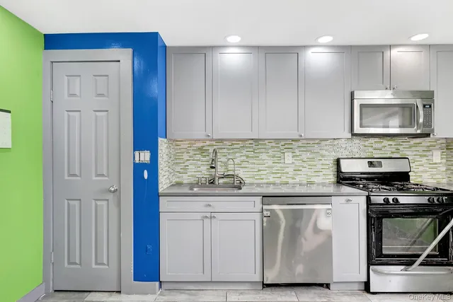 a kitchen with granite countertop a stove a sink and a microwave