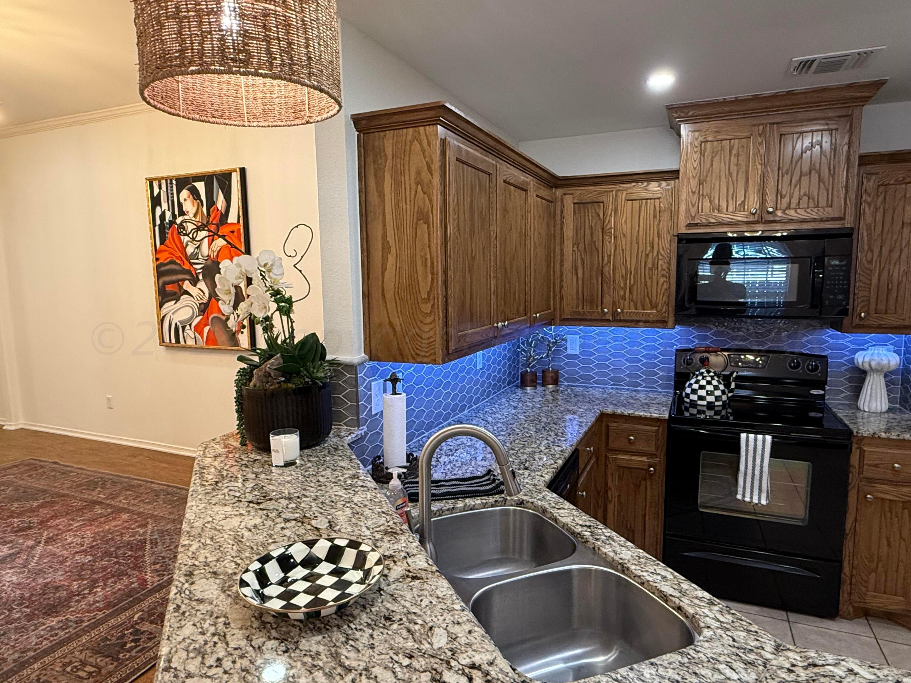 4528 Ida Louise Court Amarillo, TX 79110 - Photo 1 of 25 a kitchen with stainless steel appliances granite countertop a stove a sink and a microwave