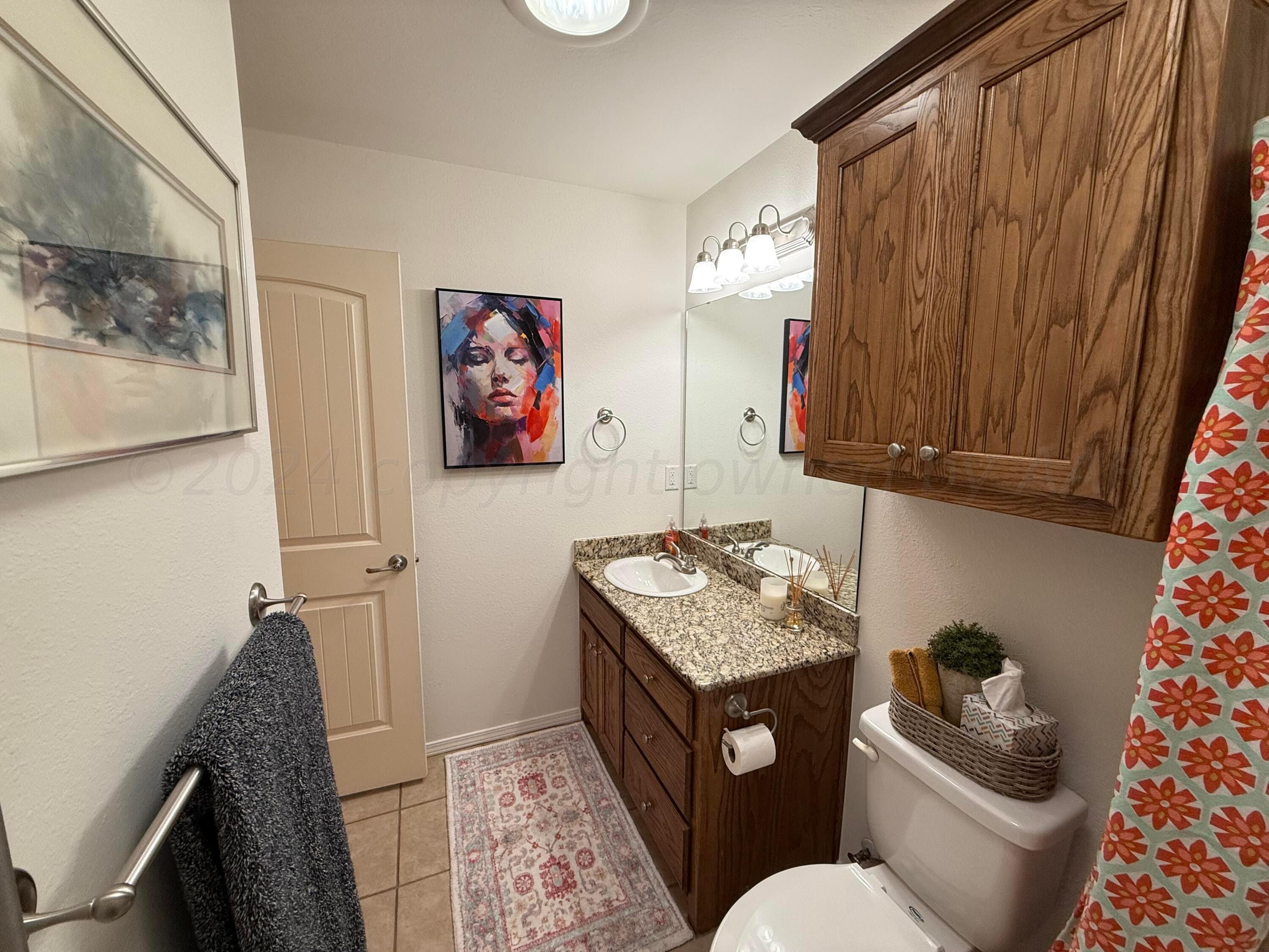 4528 Ida Louise Court Amarillo, TX 79110 - Photo 20 of 25 a bathroom with a granite countertop toilet sink and mirror