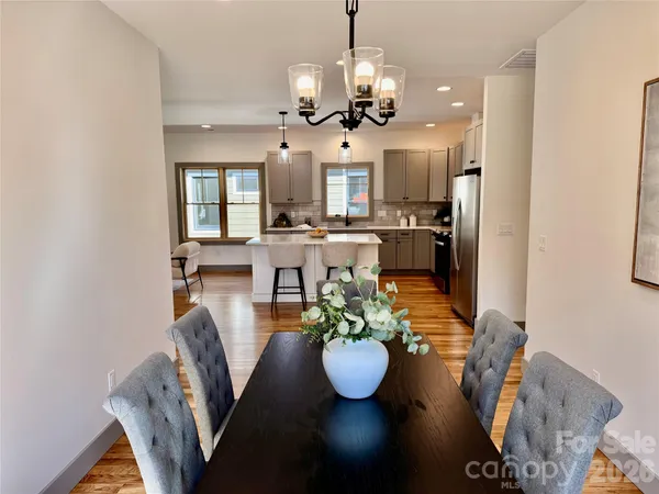 a view of a dining room with furniture a chandelier and wooden floor